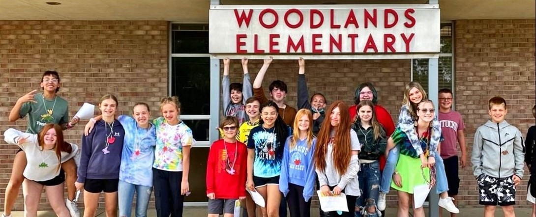 Student standing in front of Woodlands Elementary 